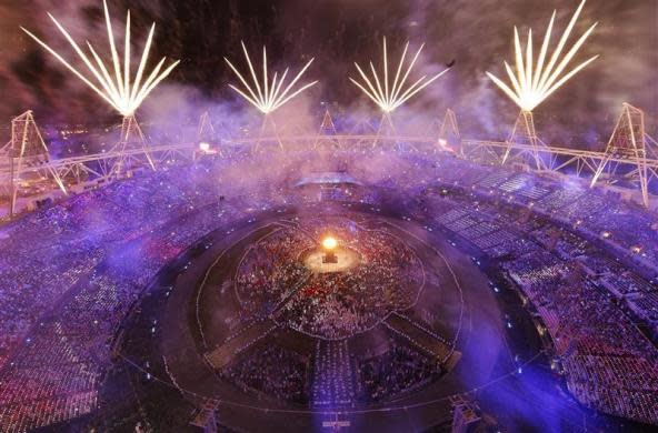 Fireworks explode over the lit Olympic Cauldron during the opening ceremony of the London 2012 Olympic Games at the Olympic Stadium July 27, 2012.