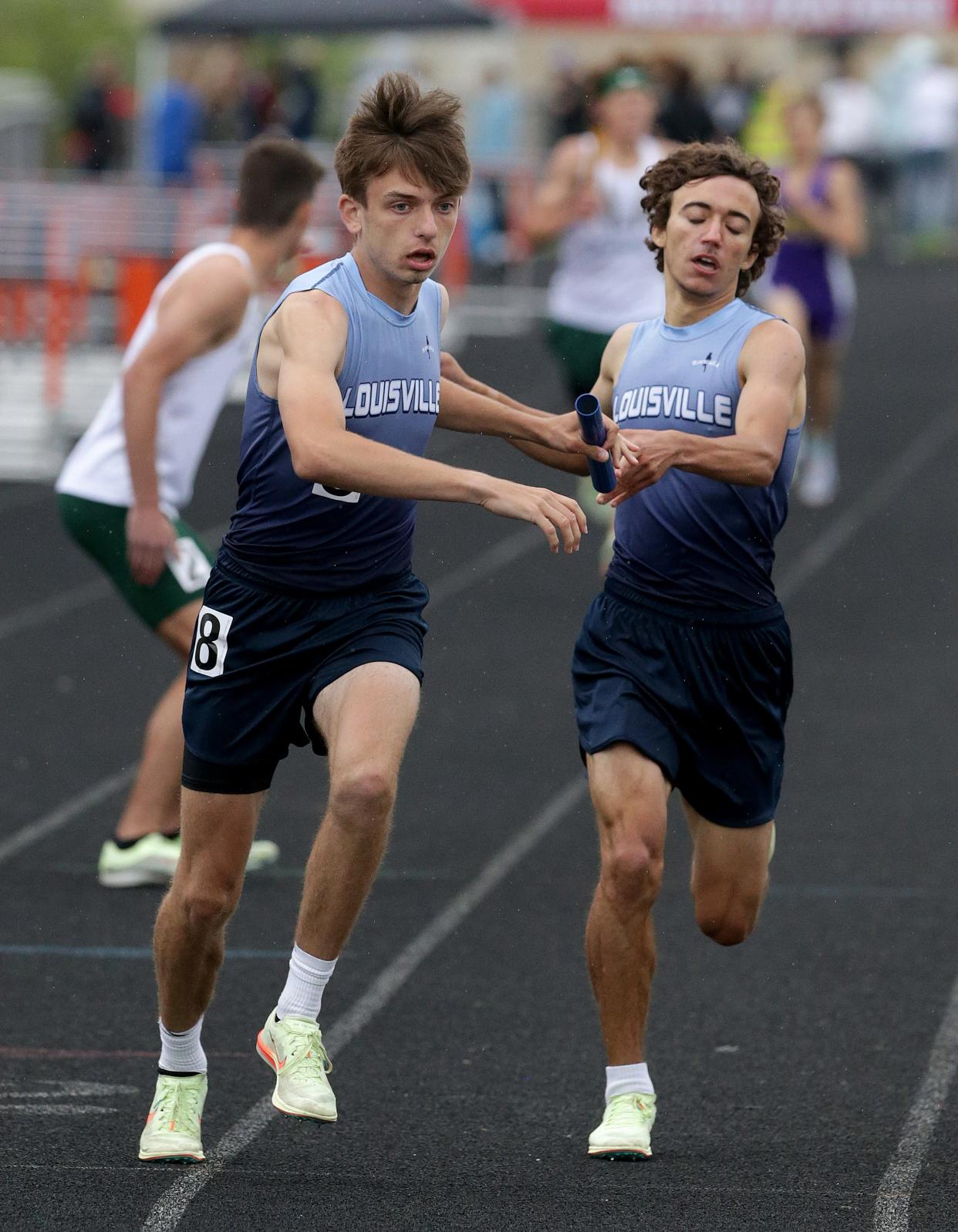 Louisville's Colby Adams hands off to Bobby Ganser to run the anchor leg of the boys 3,200-meter relay in the Division I district track and field meet at Hoover.