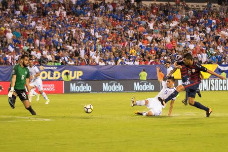 Jul 19, 2017; Philadelphia, PA, USA; United States defender Eric Lichaj (15) scores a goal past El Salvador goalkeeper Derby Carrillo (18) and defender Ivan Mancia (5) during the first half at Lincoln Financial Field. Mandatory Credit: Bill Streicher-USA TODAY Sports