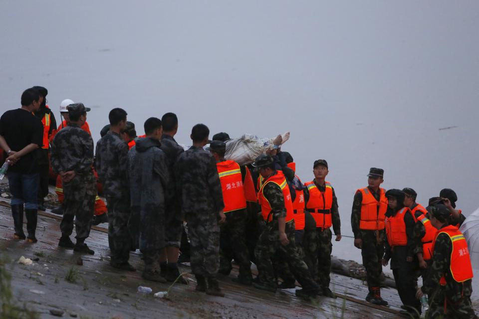 Rescue workers carry a body from the sunken ship in the Jianli section of Yangtze River