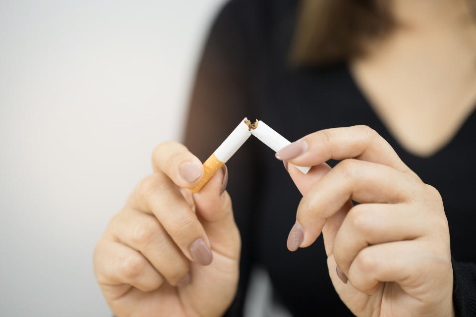 A photo of a black woman holding a cigarette