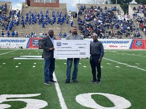 Jared Mitchell (left), Store Manager, Store #236, Hillsville, VA, and Garland Scarboro (right), Manager, Diversity, Equity & Inclusion, Food Lion, make a check presentation at the CIAA championship game between Fayetteville State University and Chowan University. *The total meals provided for the season will increase due to upcoming playoffs, championships or bowl games. Food Lion Feeds provides up to 2,000 meals for every quarterback sack made in a playoff, championship or bowl game.