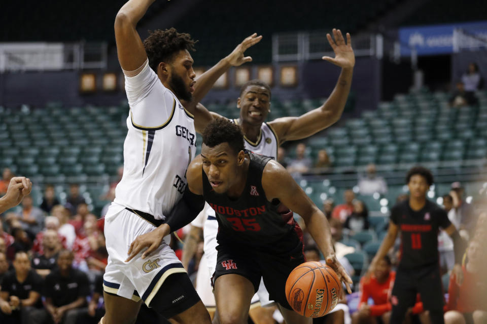 After grabbing a rebound, Houston forward Fabian White Jr. (35) tries to get past Georgia Tech forwards James Banks III. left, and Moses Wright during the second half of an NCAA college basketball game Monday, Dec. 23, 2019, in Honolulu. (AP Photo/Marco Garcia)