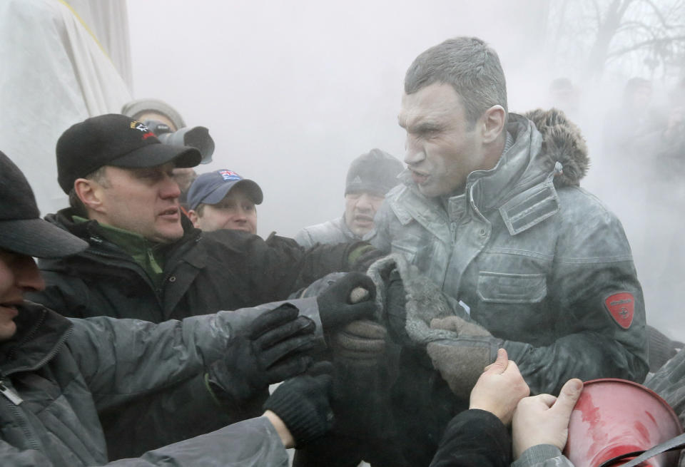 Opposition leader and former WBC heavyweight boxing champion Vitali Klitschko, right, is attacked and sprayed with a fire extinguisher as he tries to stop clashes between police and protesters in central Kiev, Ukraine, Sunday, Jan. 19, 2014. Anti-government protests in Ukraine's capital escalated into fiery street battles with police Sunday as thousands of demonstrators hurled rocks and firebombs to set police vehicles ablaze. Dozens of officers and protesters were injured. The violence was a sharp escalation of Ukraine's two-month political crisis, which has brought round-the-clock protest gatherings, but had been largely peaceful. The crisis erupted in November after President Viktor Yanukovych's decision to freeze ties with the European Union and seek a huge bailout from Russia. (AP Photo/Efrem Lukatsky)