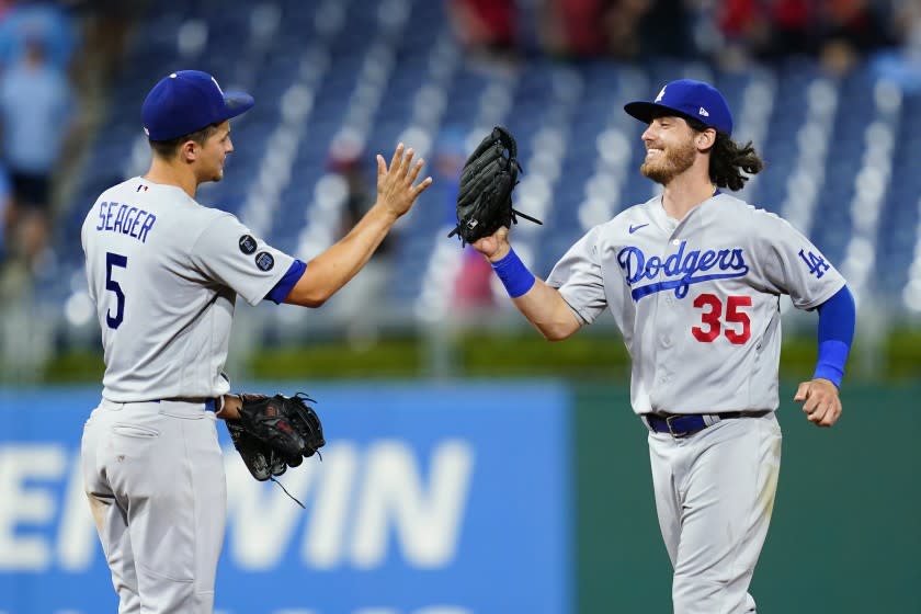Los Angeles Dodgers' Corey Seager, left, and Cody Bellinger celebrate after the Dodgers won a baseball game against the Philadelphia Phillies, early Wednesday morning, Aug. 11, 2021, in Philadelphia. (AP Photo/Matt Slocum)