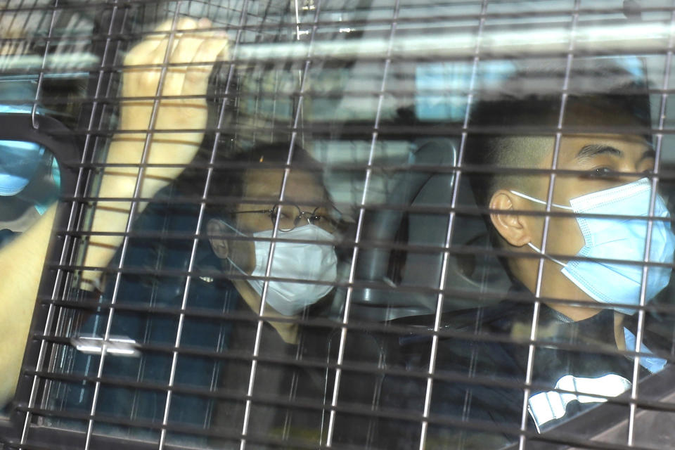 Former law professor Benny Tai, left, a key figure in Hong Kong's 2014 Occupy Central protests and also was one of the main organizers of the primaries, who was arrested under Hong Kong's national security law, arrives at a court in a police van in Hong Kong Monday, March 1, 2021. Hong Kong police on Sunday detained 47 pro-democracy activists on charges of conspiracy to commit subversion under the city's national security law, in the largest mass charge against the semi-autonomous Chinese territory's opposition camp since the law came into effect last June. (AP Photo/Apple Daily)