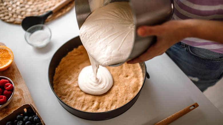 Pouring cheesecake into crust