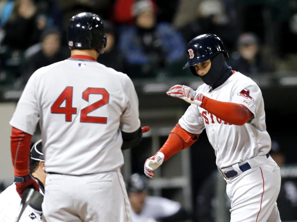 Boston Red Sox's Daniel Nava, right, is greeted at home by A.J. Pierzynski after Nava hit a home run off Chicago White Sox starting pitcher Erik Johnson during the fourth inning of a baseball game Tuesday, April 15, 2014, in Chicago. (AP Photo/Charles Rex Arbogast)