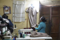 Seamstress Lupe de la Cruz, 55, checks one of the two dresses she has made for Peru's future first lady, Lilia Paredes, in her workshop where she lives with her 86-year-old mother and her dog Bobby, near Chugur, Peru, Thursday, July 22, 2021. Paredes' husband, leftist Pedro Castillo catapulted from unknown to president-elect with the support of the country's poor and rural citizens, many of whom identify with the struggles the teacher has faced. (AP Photo/Franklin Briceno)