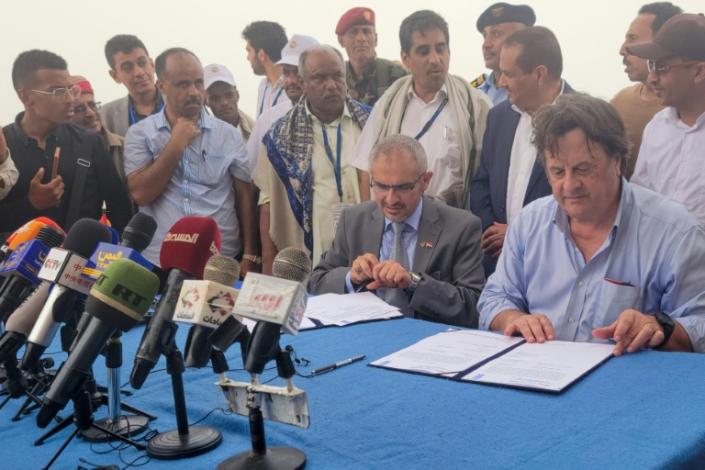 UN resident coordinator for Yemen David Gressly (R) and Edrees al-Shami (2nd-R), the Huthi-appointed executive general manager of SEPOC, sign documents on board the UN-owned Nautica vessel off the coast of Yemen's western port of Hodeida (Mohammed HUWAIS)