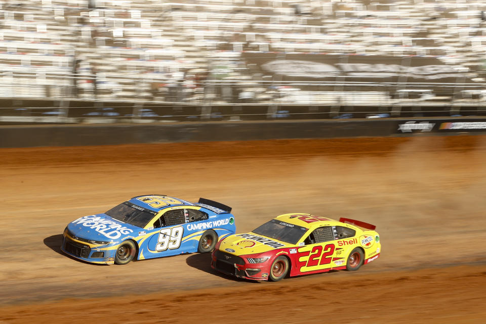 Driver Joey Logano (22) races with Daniel Suarez (99) through Turn 4 during a NASCAR Cup Series auto race, Monday, March 29, 2021, in Bristol, Tenn. (AP Photo/Wade Payne)
