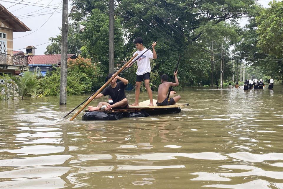 Local residents ride a raft made with inner-tubes along a flooded road in Bago, Myanmar, about 80 kilometers (50 miles) northeast of Yangon, Friday, Aug. 11, 2023. (AP Photo)
