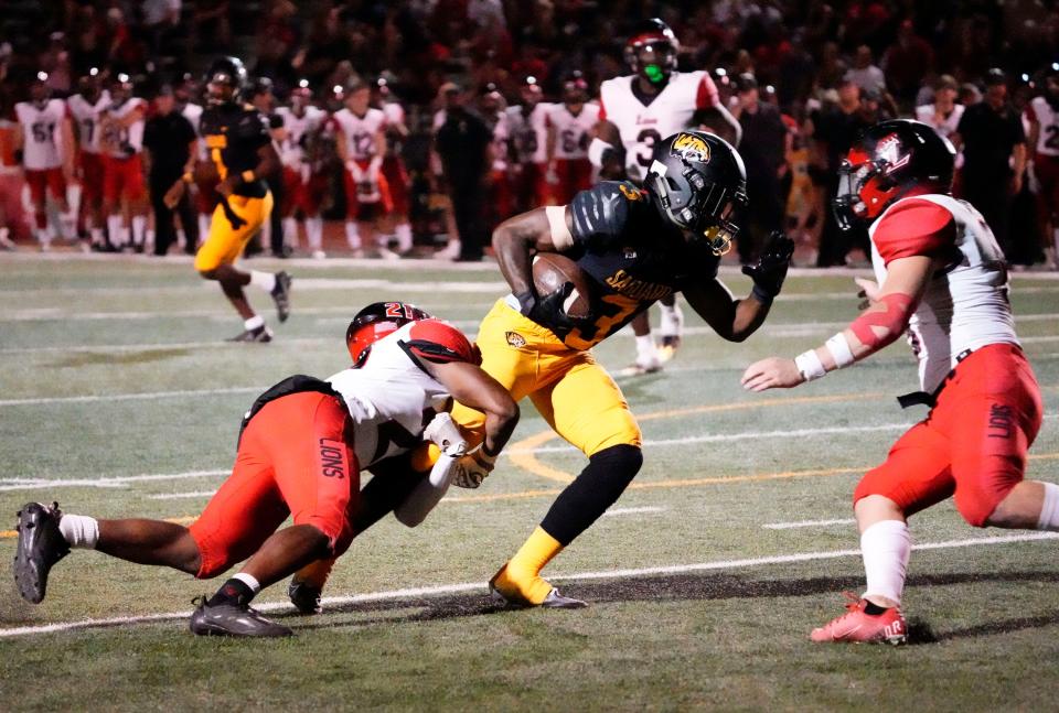 Sep 30, 2022; Scottsdale, AZ, USA; Saguaro Sabercats running back Jaedon Matthews (3) is tackled by Liberty Lions defensive back Daveed Umoren (21) during a game played at Saguaro High. Mandatory Credit: Rob Schumacher-Arizona Republic