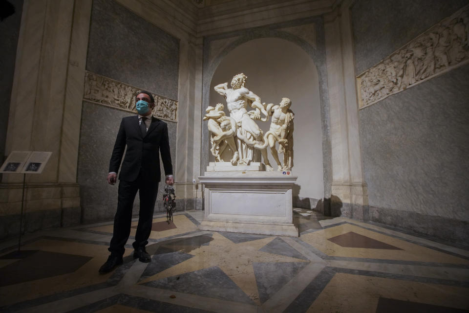 Gianni Crea, the Vatican Museums chief "Clavigero" key-keeper, walks past the Laocoon statue, a masterpiece of the sculptors of Rhodes dated around 40-30 B.C., on his way to open the museum's rooms and sections, at the Vatican, Monday, Feb. 1, 2021. Crea is the “clavigero” of the Vatican Museums, the chief key-keeper whose job begins each morning at 5 a.m., opening the doors and turning on the lights through 7 kilometers of one of the world's greatest collections of art and antiquities. The Associated Press followed Crea on his rounds the first day the museum reopened to the public, joining him in the underground “bunker” where the 2,797 keys to the Vatican treasures are kept in wall safes overnight. (AP Photo/Andrew Medichini)