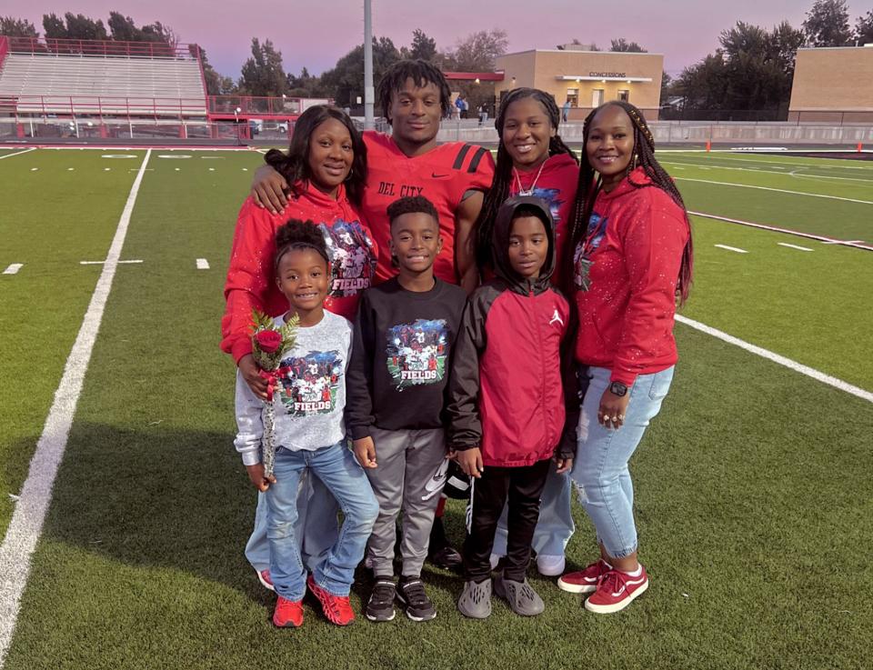 Rodney Fields Jr. poses with his family on Del CityÕs senior night. His mother, Chiquita Richards (left), made the custom shirts for RodneyÕs family fan club. Photo provided by Chiquita Richards