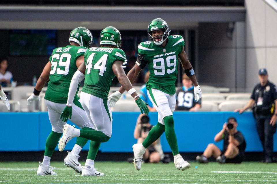 Will McDonald IV (99) celebrates with teammates Bruce Hector (69) and Jamien Sherwood (44) after registering a sack against the Carolina Panthers.