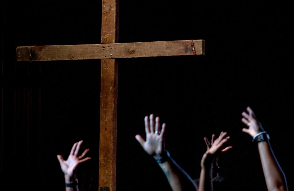 Dancers perform beneath a giant cross during a final rehearsal for the production, Upon this Rock, Wednesday, April 5, 2023 at the Pike Performing Arts Center. For 40 years, churches from around Indy have come together to perform the Passion play. Though the Easter-time program started with one church, this year it includes participants from up to 70 churches. This will be the final year, with performances through Easter at Pike Performing Arts Center.