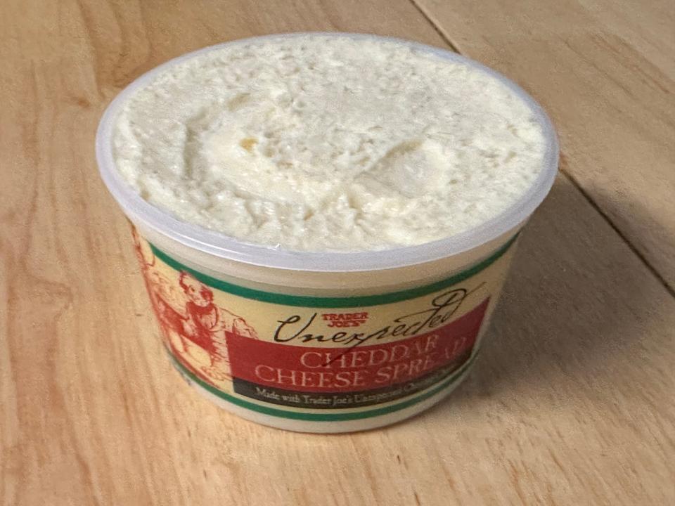 open beige, red, and green container of trader joe's unexpected cheddar dip