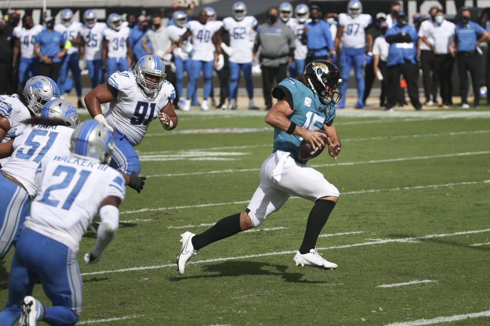 Jacksonville Jaguars quarterback Gardner Minshew II, right, scrambles past the Detroit Lions defense for a 6-yard touchdown during the second half of an NFL football game, Sunday, Oct. 18, 2020, in Jacksonville, Fla. (AP Photo/Stephen B. Morton)