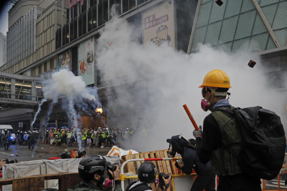 Policemen clash with demonstrators on a street during a protest in Hong Kong, Sunday, Aug. 25, 2019. Hong Kong police have rolled out water cannon trucks for the first time in this summer's pro-democracy protests. The two trucks moved forward with riot officers Sunday evening as they pushed protesters back along a street in the outlying Tsuen Wan district. (AP Photo/Kin Cheung)