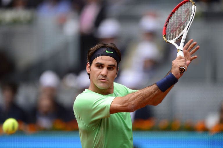 Swiss player Roger Federer returns the ball to his Czech opponent Radek Stepanek (not in picture) during their match at the Madrid Open on May 7, 2013. Federer made a winning return after a two-month absence from the court as he cruised to 6-3, 6-3 win over Stepanek to move into the third round of the Madrid Open