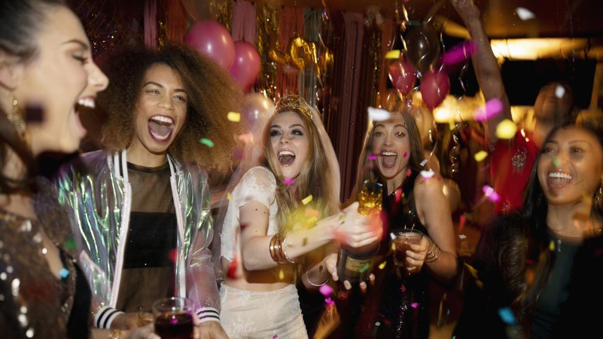 confetti falling over laughing bachelorette and friends in nightclub