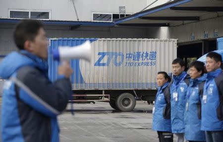 Workers listen to their line manager, at a sorting centre of Zhongtong (ZTO) Express, Chaoyang District, Beijing, November 8, 2015. REUTERS/Jason Lee/File Photo