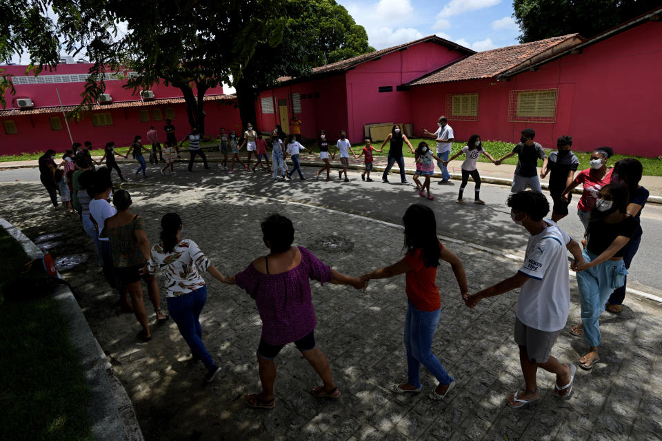 Children play during an activity day organized by the Baptist church in the Pinheiro neighborhood of Maceio, Alagoas state, Brazil, Sunday, March 6, 2022. The church has declined to close its doors even though its building is threatened by ground subsidence caused by the Braskem mine that has forced more than 55 thousand people from their homes in Maceio. (AP Photo/Eraldo Peres)