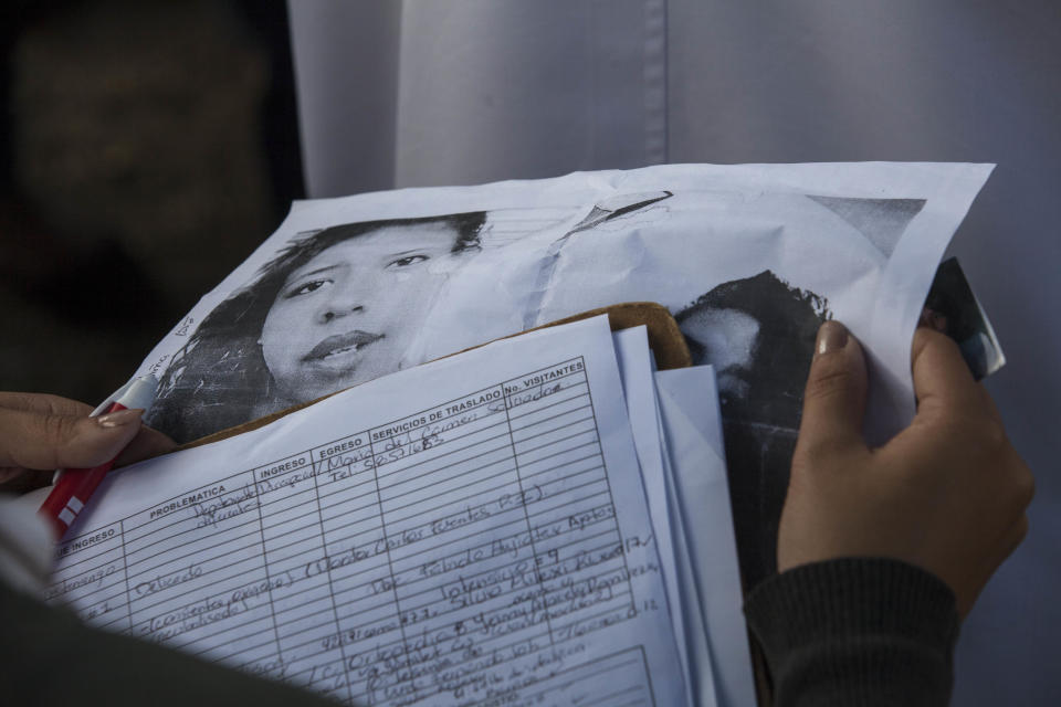 In this March 8, 2017 photo, a doctor holds photos of victims of the Virgen de la Asuncion Safe Home fire, as relatives try to identify them, outside the Roosevelt Hospital in Guatemala City. Forty girls died in the tragedy after they lit several mattress during a protest. (AP Photo/Moises Castillo)