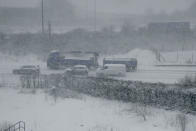 <p>Vehicles crawl along a road as snow falls in southeast England, as seen through the window of a train travelling from London to Canterbury. The Met Office said: ‘Strong winds will lead to drifting of snow and severe wind chill, while lightning could be an additional hazard, particularly near coasts.’ (AP Photo/Matt Dunham) </p>