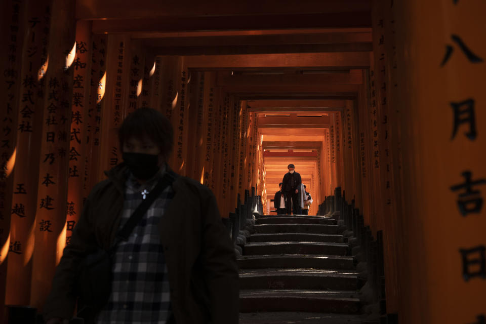 Tourists walk through torii gates at Fushimi Inari Shrine in Kyoto, Japan, March 18, 2020. Japanese tourism industry has taken a beating after Beijing banned group tours in late January. (AP Photo/Jae C. Hong)