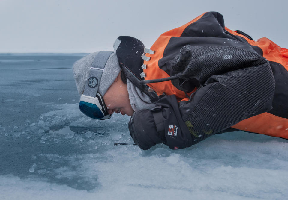 Researcher Dr. Alison Fong peers through the Arctic Sea ice during a year-long mission aboard the RV Polarstern to evaluate the impact of climate change on the Arctic. / Credit: Alfred Wegener Insititute / Lianna Evans Nixon