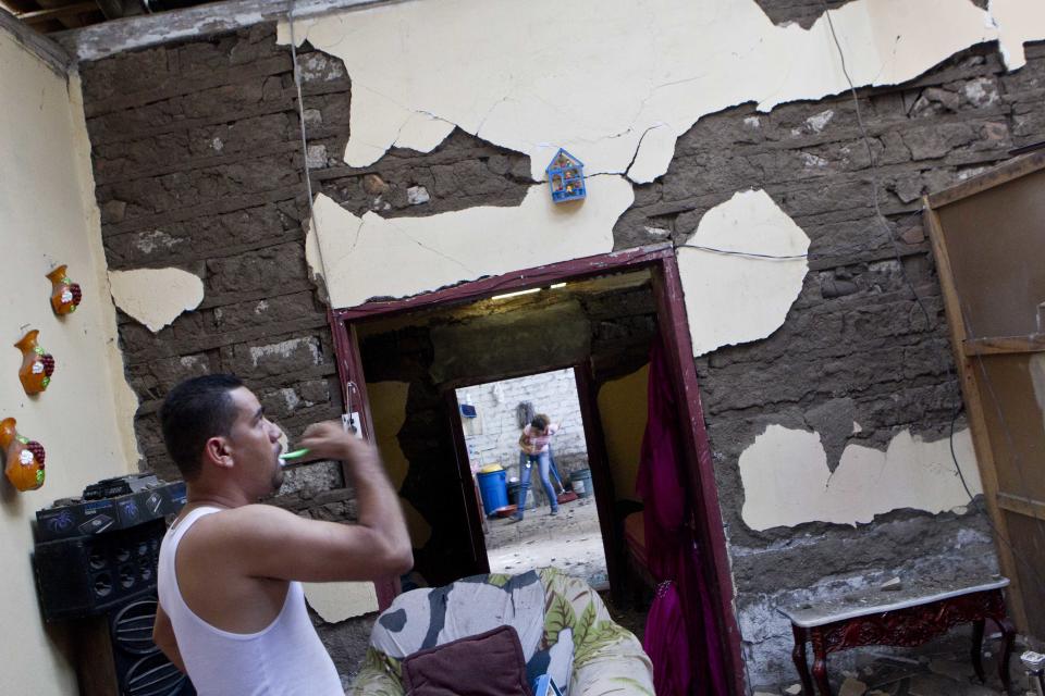 Un hombre se asea dentro de su casa dañada por los terremotos superiores a 6,2 grados de maginitud en Nagarote, Nicaragua, el viernes 11 de abril de 2014. (Foto de AP/Esteban Felix)