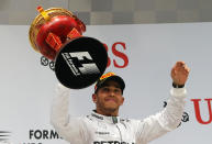 Mercedes driver Lewis Hamilton of Britain celebrates with his trophy after he wins the Chinese Formula One Grand Prix at Shanghai International Circuit in Shanghai, China Sunday, April 20, 2014. (AP Photo/Eugene Hoshiko)