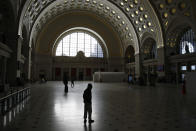 People walk in Union Station's Main Hall in Washington, Monday, March 16, 2020. The U.S. surgeon general says the number of coronavirus cases in the United States has reached the level that Italy recorded two weeks ago. It's a sign that infections are expected to rise in America as the government steps up testing and financial markets continue to fall. (AP Photo/Patrick Semansky)