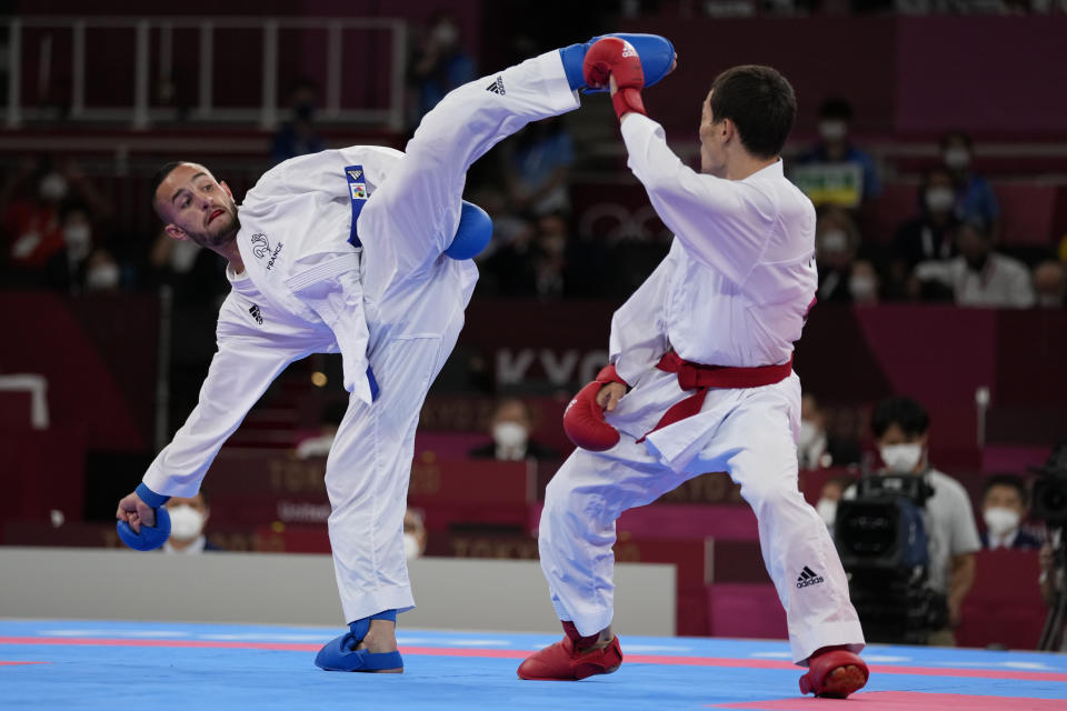 Darkhan Assadilov of Kazakhstan, right, and Steven da Costa of France compete in the men's kumite -67kg semifinal bout for Karate at the 2020 Summer Olympics, Thursday, Aug. 5, 2021, in Tokyo, Japan. (AP Photo/Vincent Thian)