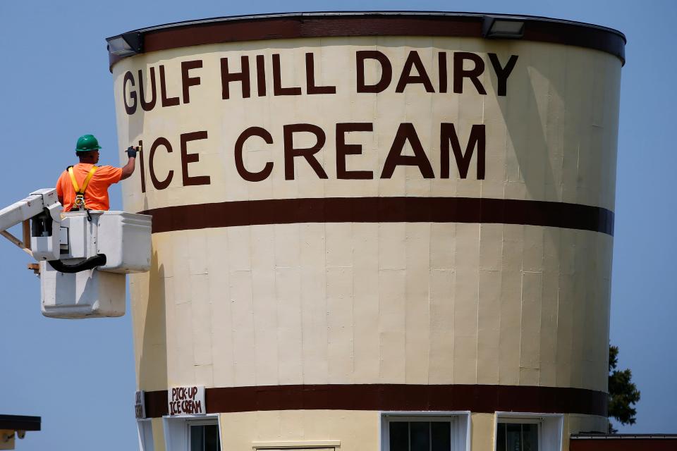 Amir Suarez of the Dartmouth Maintenance Department paints the iconic Gulf Hill Dairy Ice Cream building on Gulf Road in Dartmouth.