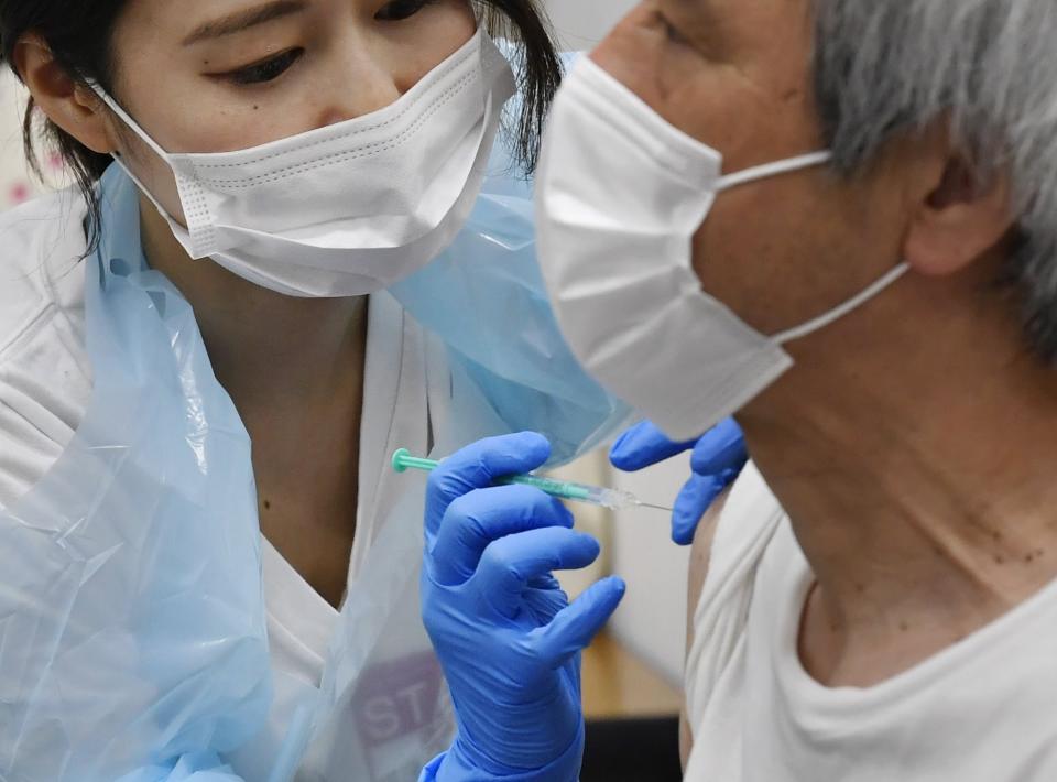 A man receives the Pfizer COVID-19 vaccine at the Noevir Stadium Kobe in Kobe, western Japan, Monday, May 31, 2021. The stadium is being used as an inoculation venue for local residents over 65 years old. Japan, seriously behind in coronavirus vaccination efforts, is scrambling to boost daily shots as the start of the Olympics in July closes in. (Yu Nakajima/Kyodo News via AP)