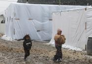 Syrian refugee children run for cover from the snow during a winter storm in Zahle town, in the Bekaa Valley December 11, 2013. The worst of winter is yet to come for 2.2 million refugees living outside Syria and millions more displaced inside the country. A storm named Alexa is sweeping across Syria and Lebanon, bringing with it high winds and freezing temperatures - and marking the beginning of the third winter since the Syrian conflict began in March 2011. In the tented settlement a few kilometres from the border in Lebanon's Bekaa Valley, more than 1,000 people live in rudimentary shelters. REUTERS/Mohamed Azakir (LEBANON - Tags: POLITICS CIVIL UNREST CONFLICT SOCIETY IMMIGRATION ENVIRONMENT)