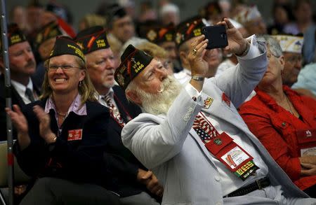 A veteran takes a picture as President Barack Obama addresses the 116th National Convention of the Veterans of Foreign Wars in Pittsburgh, Pennsylvania July 21, 2015. REUTERS/Kevin Lamarque