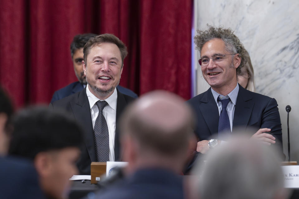 Elon Musk, CEO of X, the company formerly known as Twitter, left, and Alex Karp, CEO of the software firm Palantir Technologies, take their seats as Senate Majority Leader Chuck Schumer, D, N.Y., convenes a closed-door gathering of leading tech CEOs to discuss the priorities and risks surrounding artificial intelligence and how it should be regulated, at the Capitol in Washington, Wednesday, Sept. 13, 2023. (AP Photo/J. Scott Applewhite)