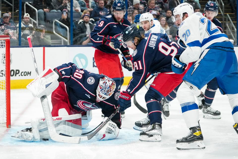 Nov 1, 2023; Columbus, Ohio, USA; Columbus Blue Jackets goaltender Elvis Merzlikins (90) makes a save in front of center Kent Johnson (91) and Tampa Bay Lightning left wing Nicholas Paul (20) during the second period of the NHL hockey game at Nationwide Arena.