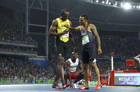 2016 Rio Olympics - Athletics - Final - Men's 200m Final - Olympic Stadium - Rio de Janeiro, Brazil - 18/08/2016. (From L) Usain Bolt (JAM) of Jamaica, Alonso Edward (PAN) of Panama and Andre De Grasse (CAN) of Canada react after their race. REUTERS/Lucy Nicholson