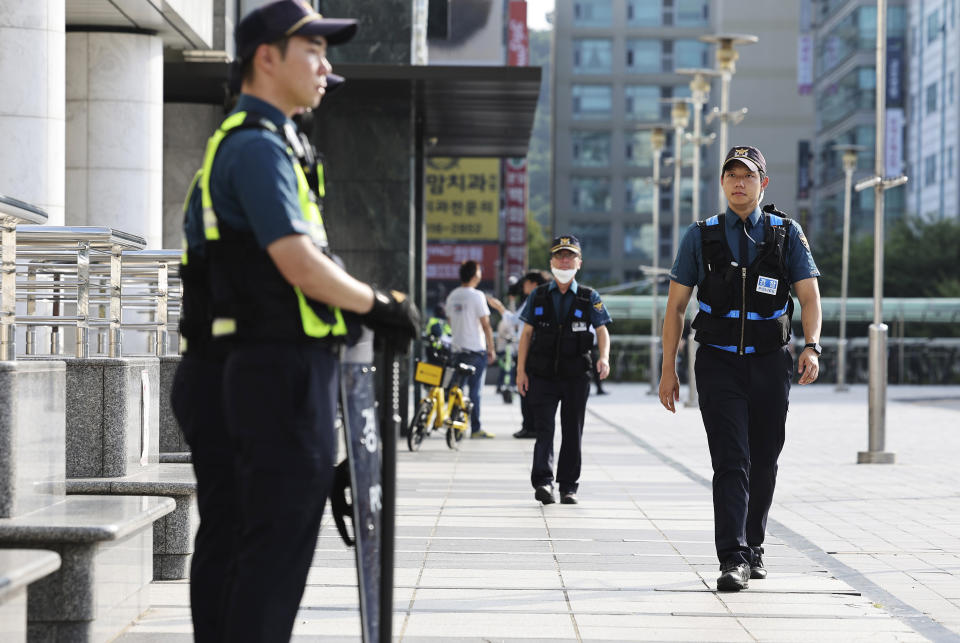 Police officers patrol around the Seohyeon subway station in Seongnam, South Korea, Friday, Aug. 4, 2023. A man rammed a car onto a sidewalk Thursday and then stepped out of the vehicle and began stabbing people near the subway station in the city of Seongnam. On Friday, South Korean police are chasing the suspect in a stabbing attack in at a high school in the central city of Daejeon. (Hong Ji-won/Yonhap via AP)