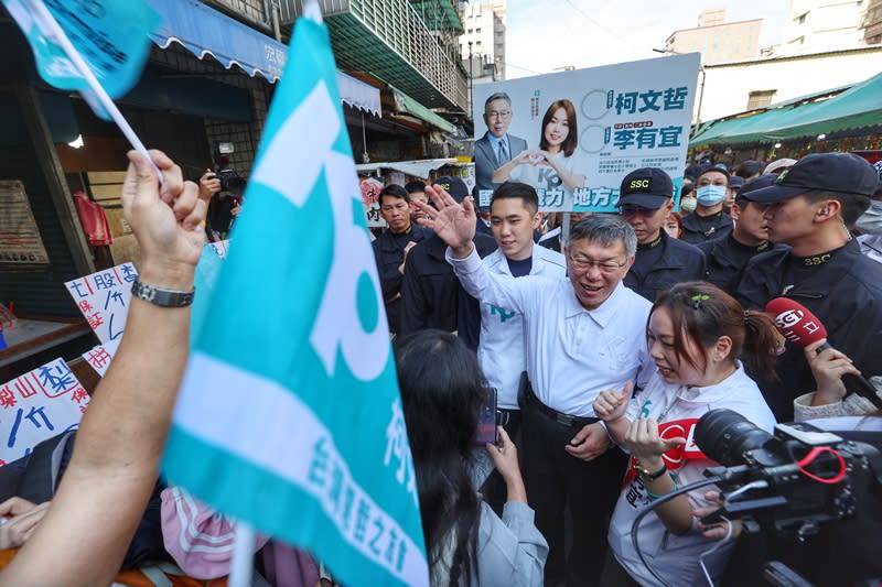 民眾黨總統參選人柯文哲（前右2）9日上午前往新北市蘆洲水流公市場陪同民眾黨立委參選人李友宜（前右）一同掃街拜票，現場有支持者搖旗高喊「凍蒜」口號。（中央社）