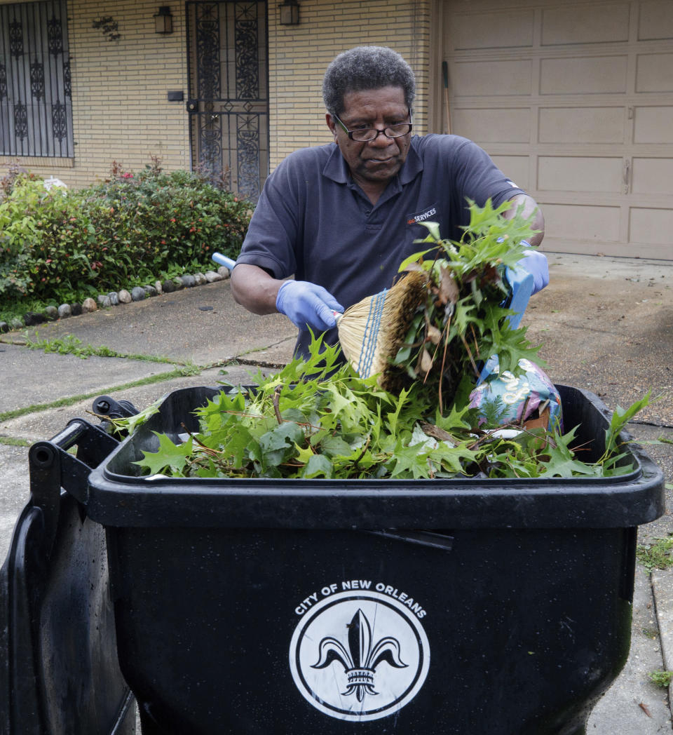 Moses Coleman Jr. cleans up debris at his home after powerful storms rolled through the city overnight in New Orleans Wednesday, May 12, 2021. (David Grunfeld/The Advocate via AP)