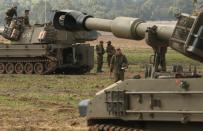 ISRAEL/GAZA BORDER, ISRAEL- NOVEMBER 19: Israeli soldiers prepare an artillery emplacement overlooking Gaza on November 19, 2012 on Israel's border with the Gaza Strip. The death toll has risen to at least 85 killed in the air strikes, according to hospital officials, on day six since the launch of operation 'Pillar of Defence.' (Photo by Christopher Furlong/Getty Images)