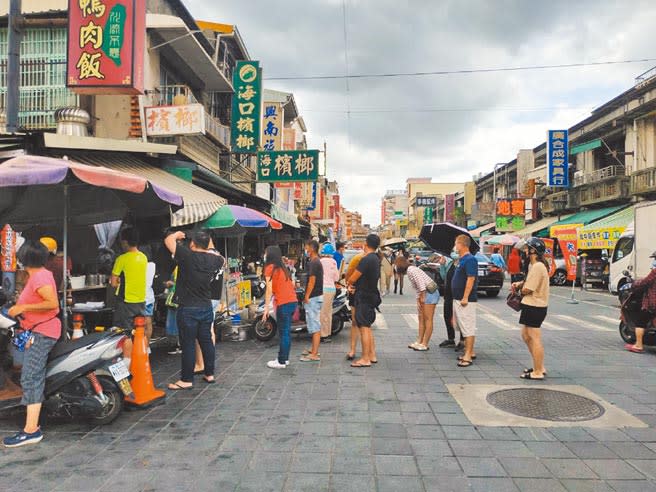 全國疫情警戒27日起降至二級。圖為降級前假日，雲林縣北港朝天宮知名排隊小吃湧現人潮。（張朝欣攝）