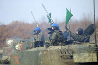 The crew of a Japanese Ground-Self Defense Force (JGDDF) Type 90 tank prepares for the maneuvers during an annual exercise at the Minami Eniwa Camp Tuesday, Dec. 7, 2021, in Eniwa, Japan's northern island of Hokkaido. Dozens of tanks are rolling over the next two weeks on Hokkaido, a main military stronghold for a country with perhaps the world's most little known yet powerful army. (AP Photo/Eugene Hoshiko)