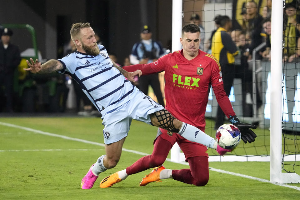 Sporting Kansas City forward Johnny Russell, left, tries to get a shot by Los Angeles FC goalkeeper Eldin Jakupovic during the first half of a Major League Soccer match Wednesday, May 17, 2023, in Los Angeles. (AP Photo/Mark J. Terrill)